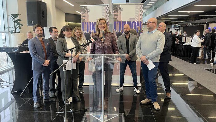 Magali Picard fait une allocution au micro accompagnée des chefs des neuf principales organisations syndicales du Québec.