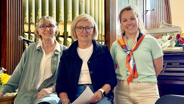 Trois femmes assisent près de l'orgue.
