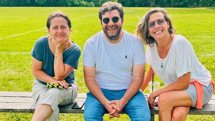 Sefika Ozlem Yaman Sahin, Orgun Ozar et une troisième personne assis sur un banc dans un parc.