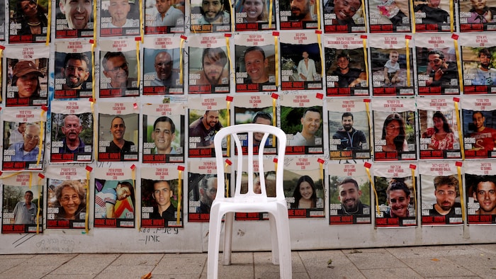 Une chaise laissée devant des affiches montrant des photos d'otages enlevés par le groupe islamiste palestinien Hamas.