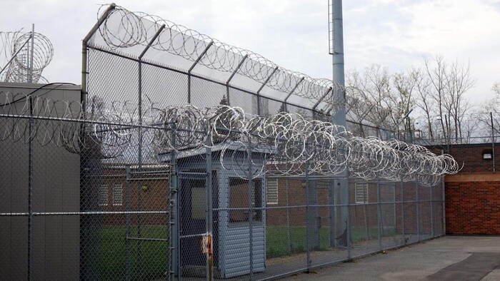 Une clôture barbelée davant un centre de détention. 