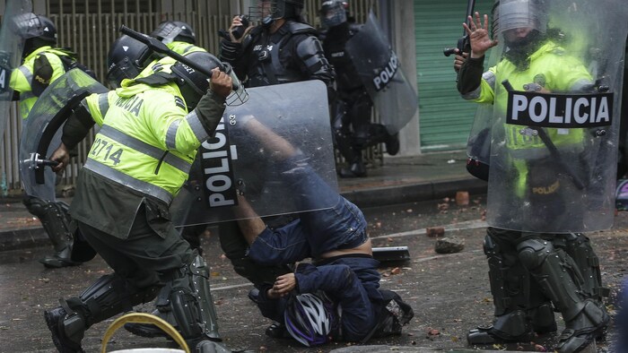 Un agente de policía se abalanza sobre un manifestante antigubernamental durante los enfrentamientos en Bogotá, Colombia, el miércoles 9 de junio de 2021. Las protestas han sido provocadas por los aumentos de impuestos propuestos en los servicios públicos, el combustible, los salarios y las pensiones. (AP Photo/Ivan Valencia)