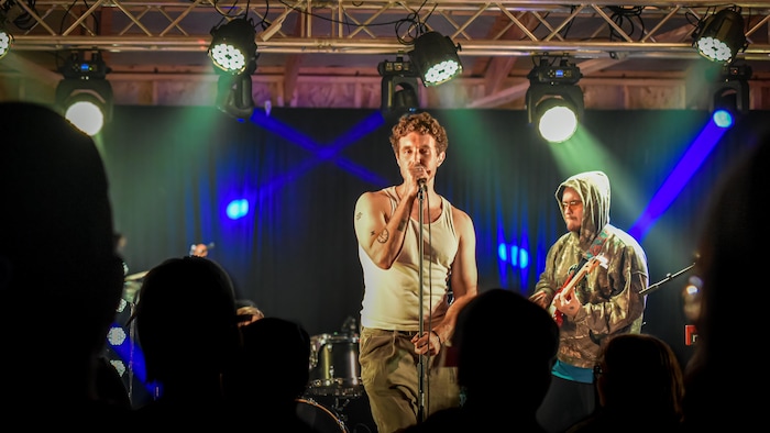 Une chanteur et un guitariste sur scène lors d'un spectacle.