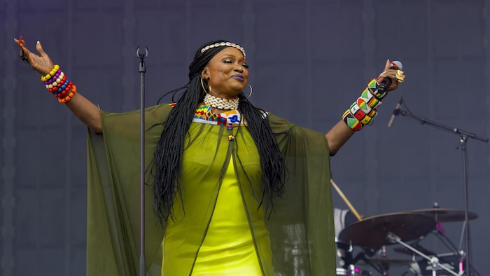 La chanteuse ouvre les bras sur scène.