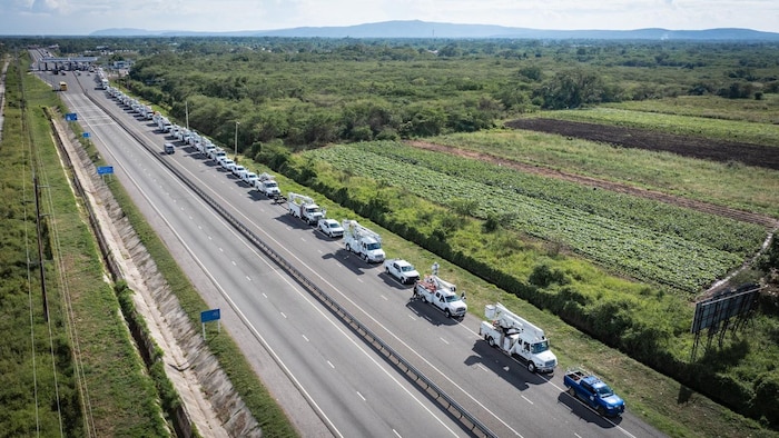 De nombreux camions stationnés le long d'une autoroute, vue du haut des airs.