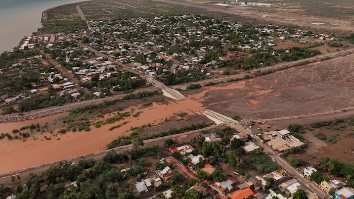 Un tronçon de route submergé par un cours d'eau, après le passage de l'ouragan Polo en Basse-Californie du Sud, à Loreto, au Mexique.