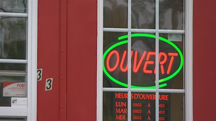 Une affiche lumineuse indique qu'un commerce est ouvert, à Gatineau.