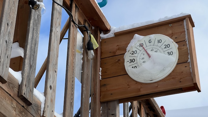 Un thermomètre extérieur couvert de neige indique -10 Celsius.