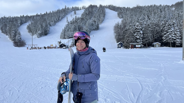Elle tient sa planche, devant les pentes du Mont Castor.