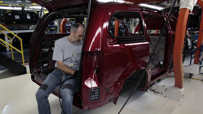 Un ouvrier assemble une Dodge Grand Caravan à l’usine de Stellantis, à Windsor.