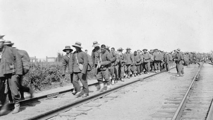 Photo d'archives de travailleurs le long d'un chemin de fer.