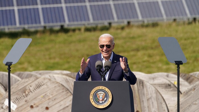 L'ex-président Joe Biden parle au micro devant des panneaux solaires au Wisconsin.