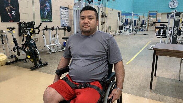 Un homme en fauteuil roulant dans un gym.