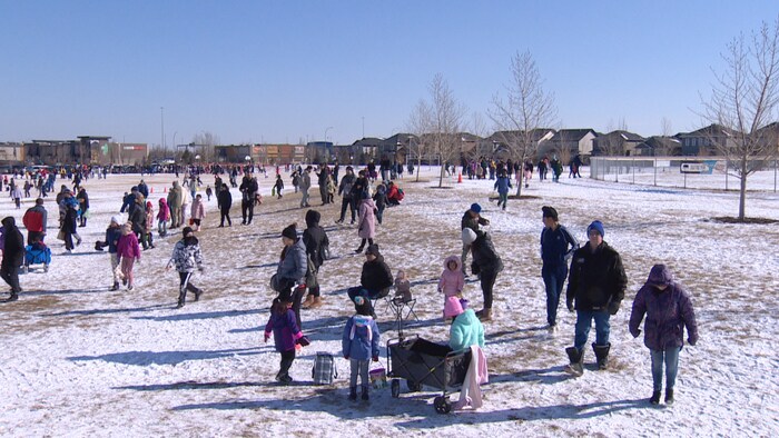 Plusieurs personnes cherchent des œufs de pacques au parc Broadmoor Lake à Sherwood Park, Alberta (mars 2024). 