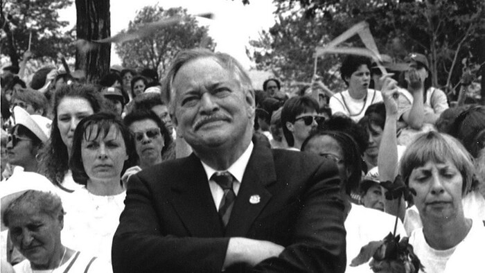 L'ancien premier ministre du Québec, Jacques Parizeau, a rejoint les femmes qui marchaient devant l'Assemblée nationale, le 4 juin 1995. Il est au centre et les femmes sont autour de lui.