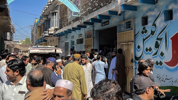 Des habitants se rassemblent lors de l’opération de recherche après l'effondrement du toit d'une école à Peshawar, le 15 octobre 2026.