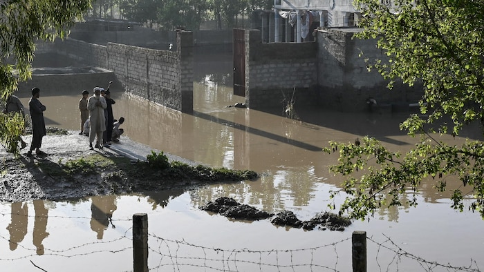 Des résidents observent l'étendue des inondations devant leur maison, le 15 avril 2024.