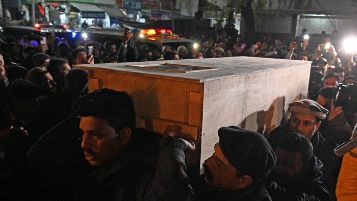 Des gens transportent le cercueil d'une victime de la tempête.