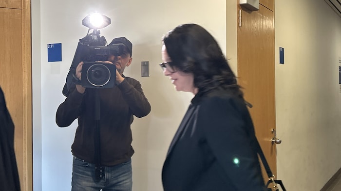 Julie Dufour passe devant un cameraman.