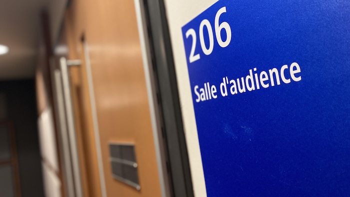 La porte d'une salle d'audience avec une pancarte indiquant la salle 206.