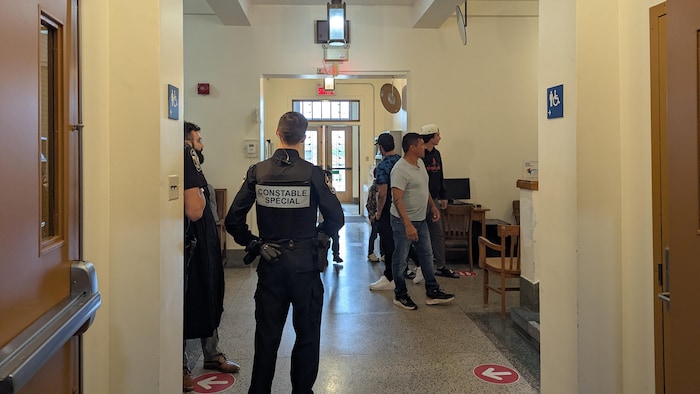 Photo prise à l'intérieur du palais de justice, où on voit un constable spécial et des membres de la communauté.