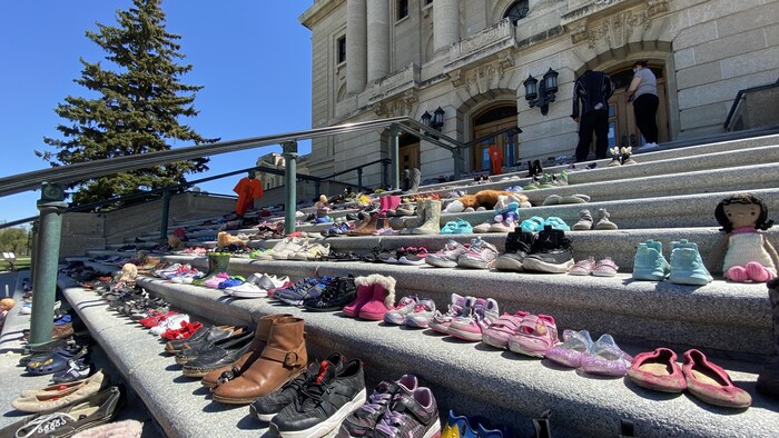 Les marches du Palais législatif de Regina, en Saskatchewan, avec 215 paires de souliers en l'honneur des corps des enfants retrouvés près du pensionnat autochtone de Kamloops.