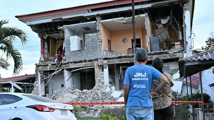 Un couple observe le bâtiment effondré du bureau du gouverneur de Penonome après le séisme qui a frappé le Panama, le 9 octobre 2026.