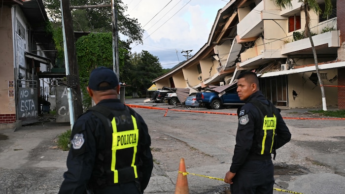 Des agents de police panaméens montent la garde près d’un édifice effondré après le séisme qui a frappé le Panama, le 9 octobre 2026.