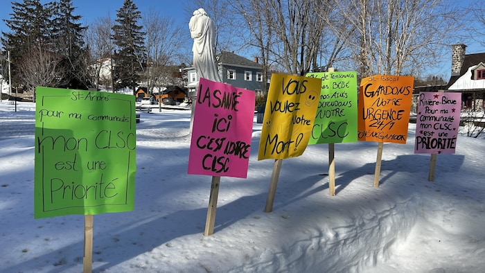 Des pancartes réalisées par les citoyens rassemblés piquées dans la neige. On peut y lire des slogans comme « La santé ici, c'est notre CLSC »