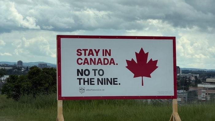 Une pancarte où il est écrit « Stay in Canada. No to the Nine. »
