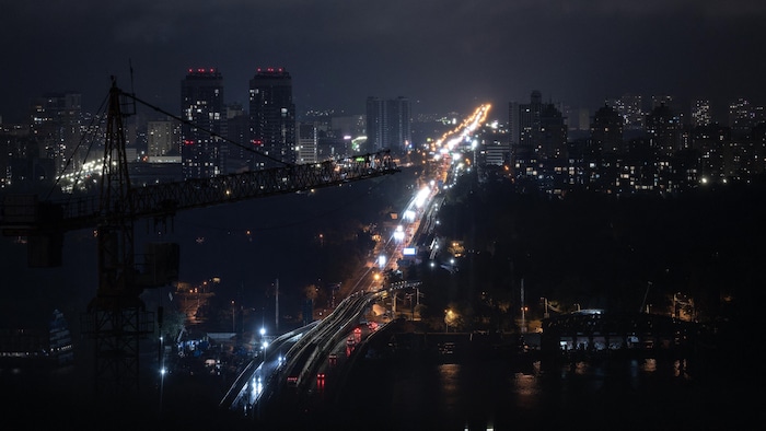 Vue aérienne d'une route et d'immeubles résidentiels de Kiev faiblement éclairés pendant la nuit.