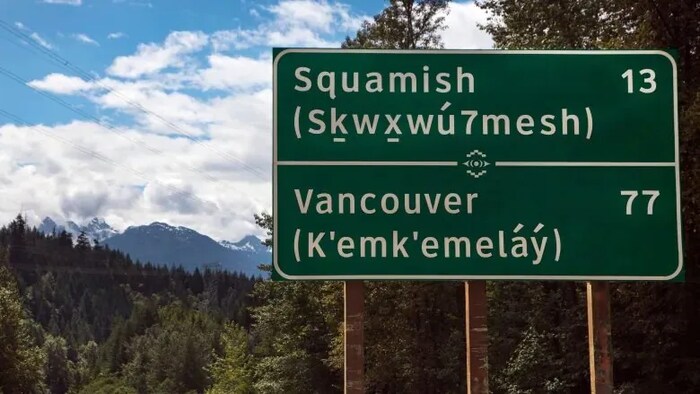 Un panneau de circulation avec le nom des villes de Squamish et Vancouver en langue autochtone.