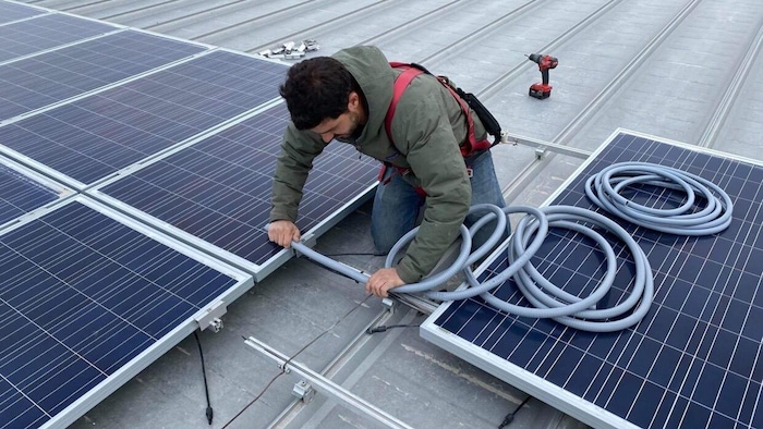 Un trabajador instala paneles solares.