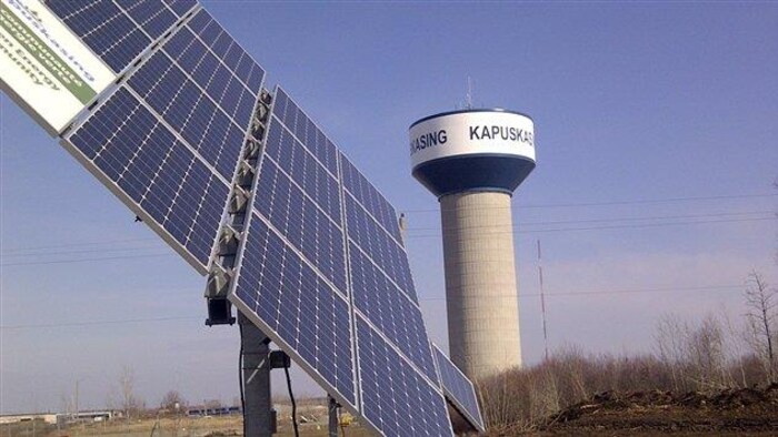 Un panneau solaire devant une tour d'eau à Kapuskasing