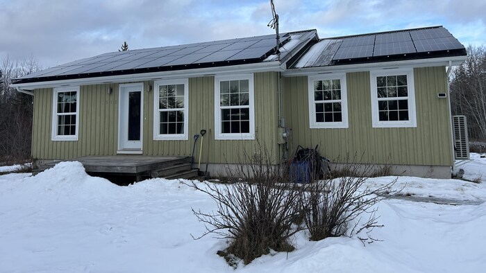 Une maison avec des panneaux solaires sur le toit.