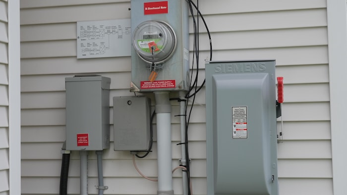 Un compteur électrique entouré d'autres appareils.