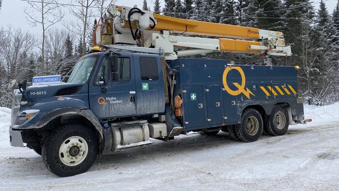 Un camion d'Hydro-Québec sur une route en hiver.