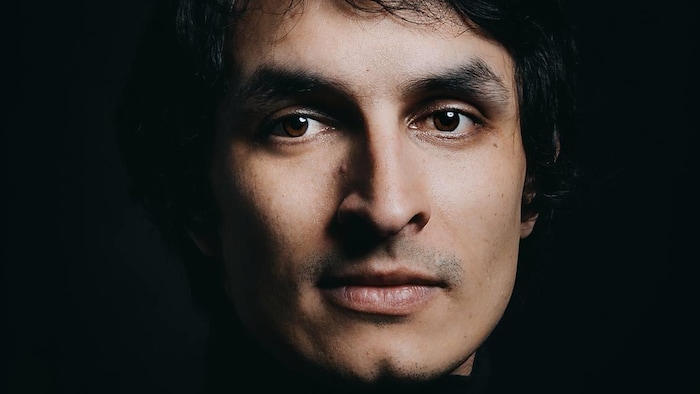 Le portrait d'un homme aux yeux et aux cheveux foncés. 