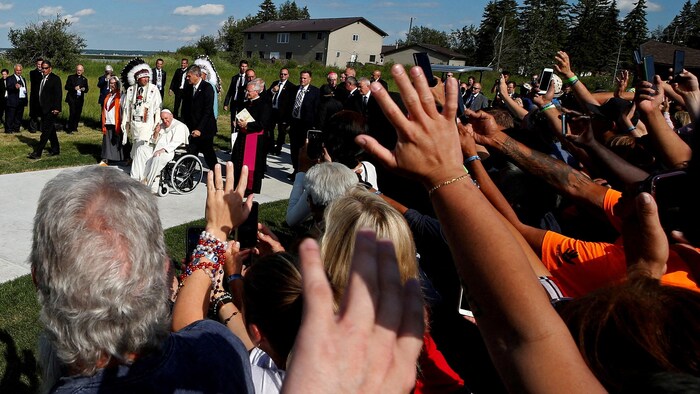 Le pape salue des fidèles.