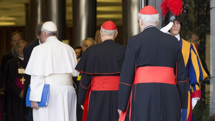 Le pape François est accompagné de cardinaux.