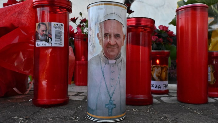 Des bougies, dont l'une avec le visage du pape.