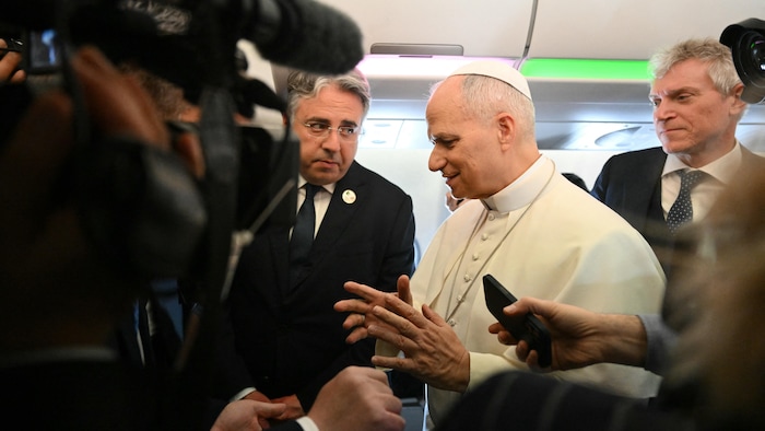 Le pape parle aux journalistes.