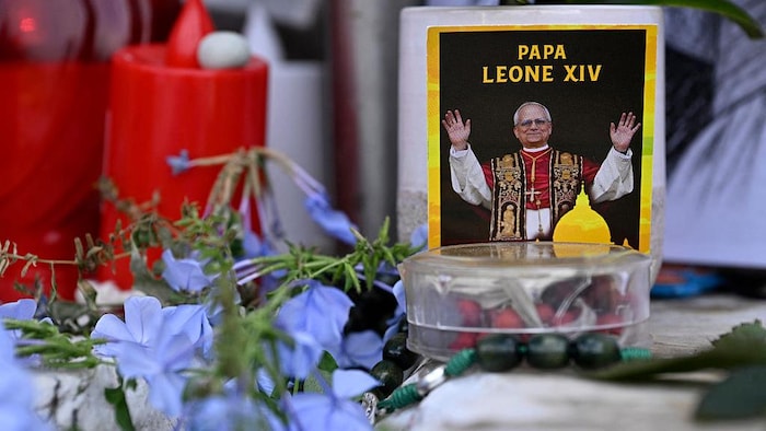 Des fleurs, des bougies et une photo du pape Léon XIV ont été déposées devant la statue de Jean-Paul II, à l'extérieur de l'hôpital universitaire Gemelli, où le pape Léon XIV se remet d'une intervention chirurgicale visant à retirer une tumeur cancéreuse de son poumon droit, à Rome, le 17 octobre 2026.  
