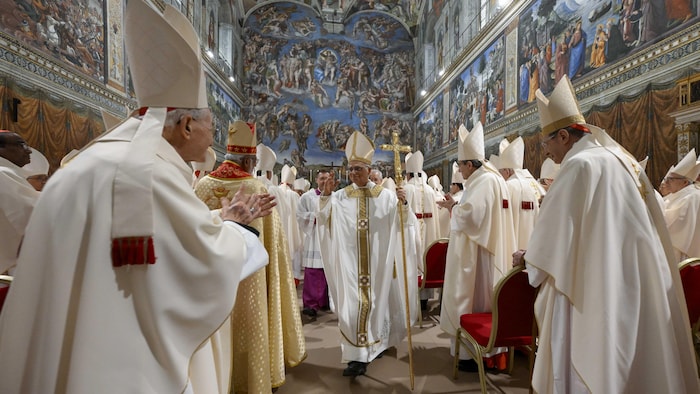 Des prêtres saluent le nouveau pape sur lad passage.
