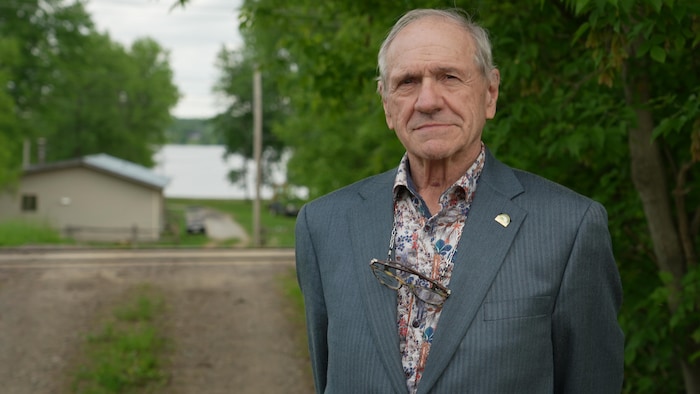 Paul-André David se laisse prendre en photo à l'extérieur. 