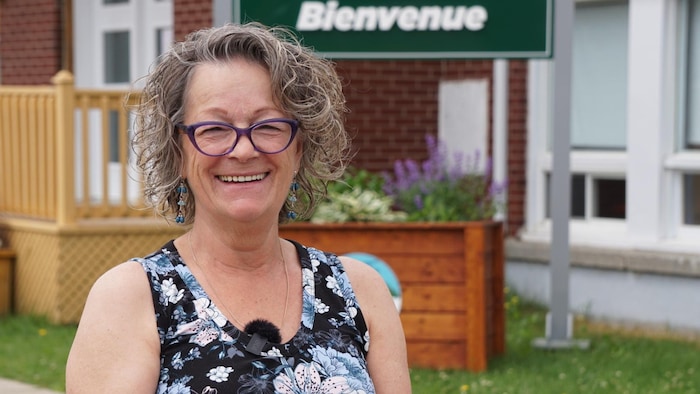La mairesse Paquerette Poirier souriante devant l'hôtel de ville de Saint-Elzéar.