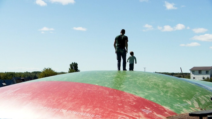 Un père et son fils sur le coussin gonflable.