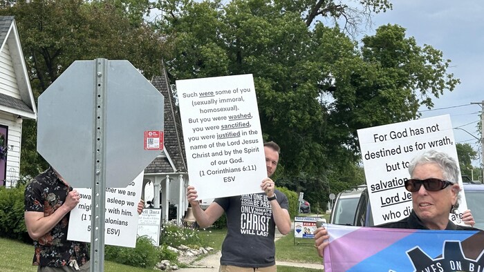 Des personnes qui montrent des pancartes.