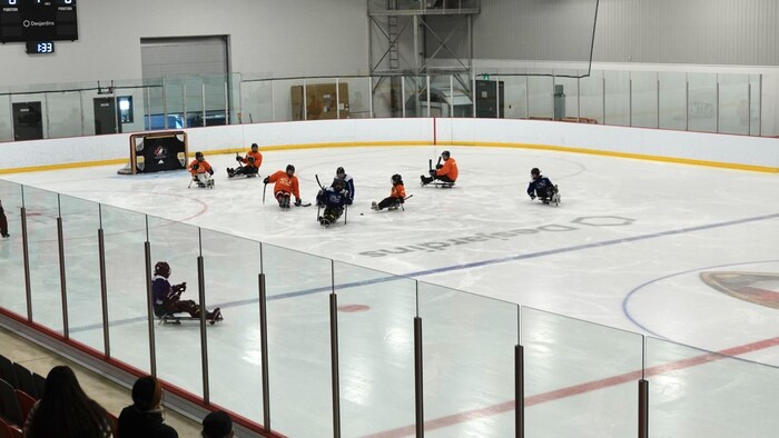 Des joueurs de parahockey sur la glace.