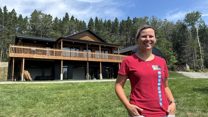 Rebecca Tremblay se tient devant un chalet d'accueil.